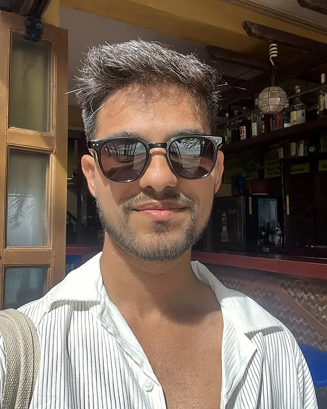 Aman in sunglasses at a beach bar